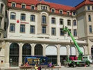 Fassade eines historischen Gebäudes mit Sparkasse-Logo, Arbeiter auf Hebebühne bei Wartungsarbeiten